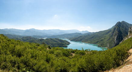 Fototapeta premium Breathtaking views of Bovilla Reservoir surrounded by lush mountains in Albania