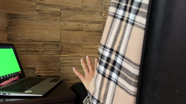 Stressed woman gesticulating during an online therapy session with her therapist while looking at a green screen laptop, highlighting mental health consultation and treatment
