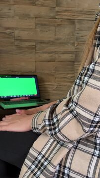 Woman attending an online therapy session via video call on a green screen laptop, gesturing while talking with a psychotherapist and seeking professional support