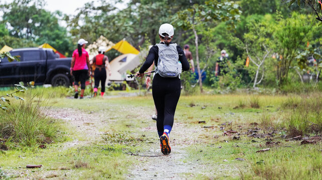 Trail runners exploring a forest path near a campsite during an outdoor adventure event