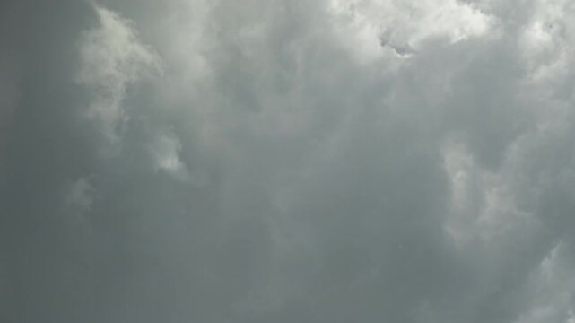 Timelapse of white cumulus clouds in blue sky changing by gray thunderclouds