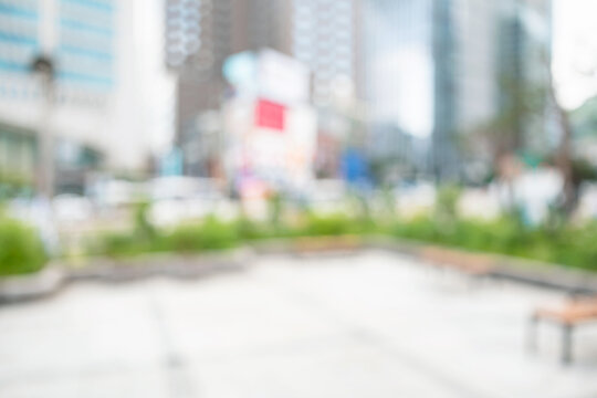 Abstract blurred modern urban office plaza background with wooden benches and skyscrapers