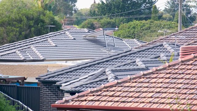 Pitched tiled rooftops, television antennas across a dense suburban residential neighborhood with single-storey homes or houses in Laverton, Melbourne, Australia