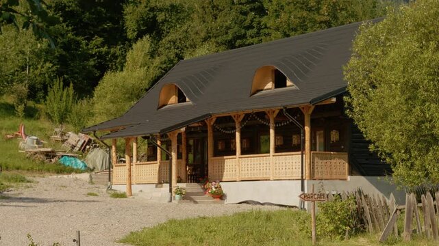 This house in Bucovina displays traditional architecture surrounded by green trees and land. It reflects local culture and the lifestyle of the area.