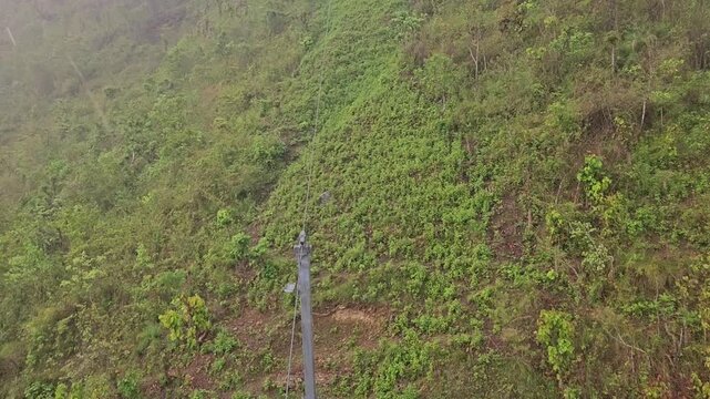 High-angle aerial view from the Manakamana cable car, looking down over dense green forest and rugged hillside terrain near the famous Manakamana Temple in Nepal.