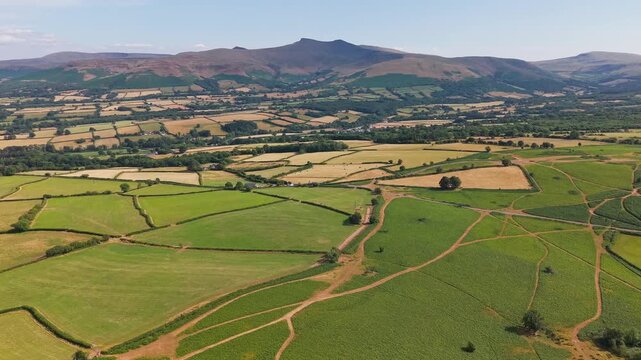 Aerial view of Pen y Fan peak in Brecon Beacons National Park, dry yellow and green patchwork fields in hot summer weather, South Wales