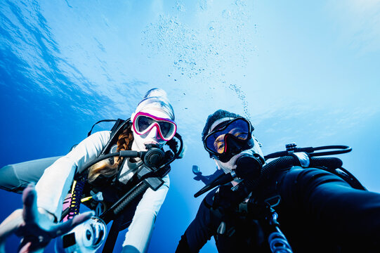 Couple taking an underwater selfie while scuba diving