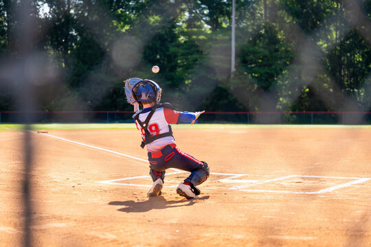 Young baseball catcher trying to catch a pitch