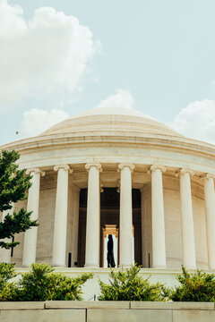 Classical memorial with columns beneath a bright summer sky.