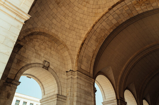 Curved stone arches and vaulted ceiling of historic building.