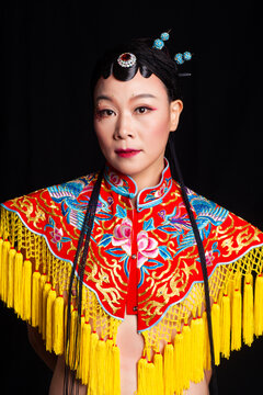 Traditional Chinese opera embroidery women in formal attire against a black background