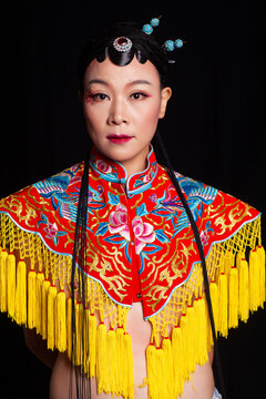 Traditional Chinese opera embroidery women in formal attire against a black background