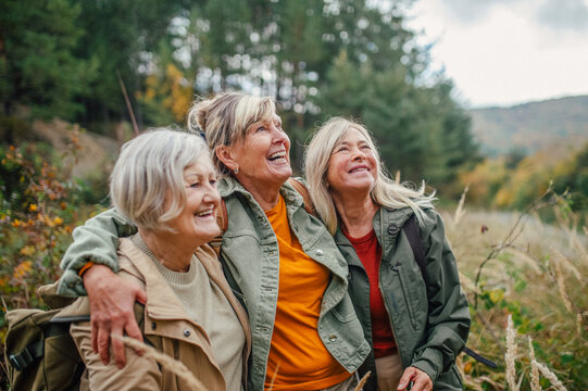 Group of mature female friends enjoying countryside walk.