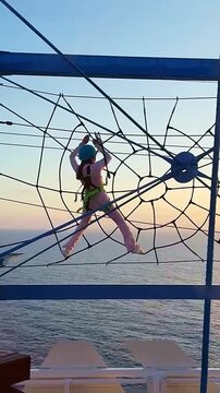 Adventure climbing net above the sea aboard a modern luxury cruise liner. Outdoor rope playground for cruise passengers with panoramic ocean view. High quality FullHD footage