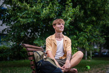 Fototapeta premium Young mang enjoying peaceful afternoon in park, sitting on bench.