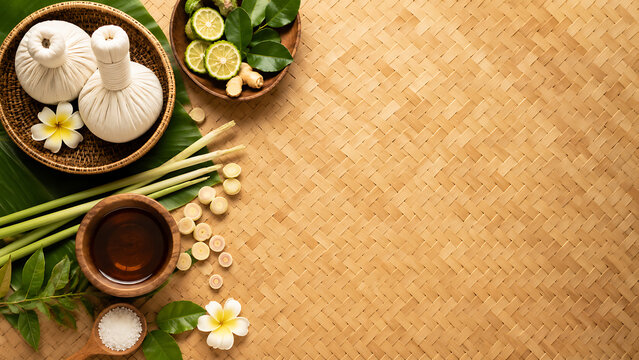 Thai herbal compress balls with lemongrass, kaffir lime and oil on woven mat