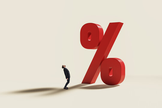 Giant red percent symbol towering over a businessperson, illustrating mortgage, loan, credit, and rising interest rates in corporate finance.