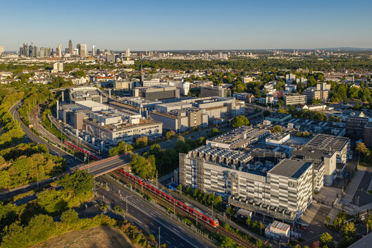 Frankfurt am Main, Hessen, Germany - 11 August 2026: Aerial view of the Global Switch data center complex, featuring a red train on tracks, urban surroundings, and the distant city skyline.