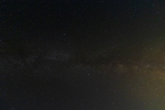 The bright band of the Milky Way galaxy stretching across a dense starry night sky