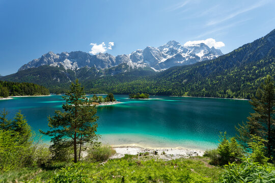 Travel landscape of Zugspitze Alps in Bavaria, Germany, scenic summer nature panorama with forest, Eibsee lake, snow mountains peak. Alpine landscape