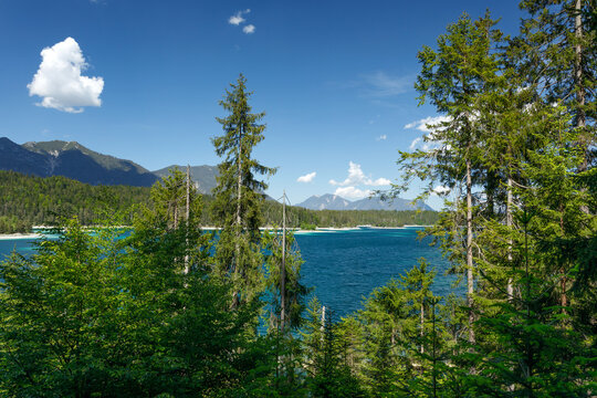 Travel landscape of Zugspitze Alps in Bavaria, Germany, scenic summer nature panorama with forest, Eibsee lake, snow mountains peak. Alpine landscape