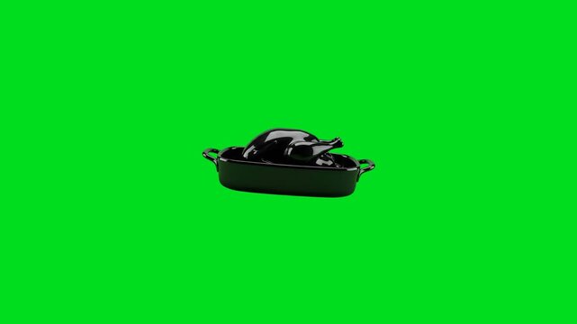 A shiny black ceramic chicken roasting pan isolated on a solid green background