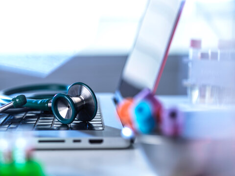 A stethoscope lies on a laptop during a medical diagnosis
