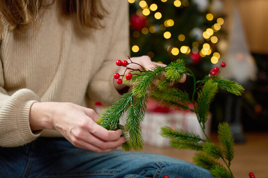 Woman decorating Christmas garland with red berries