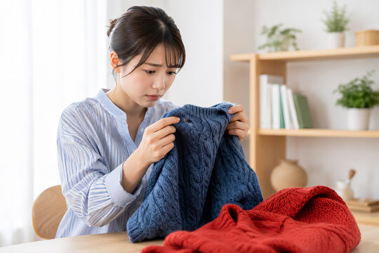 秋の衣替えでセーターの穴を発見する日本人女性