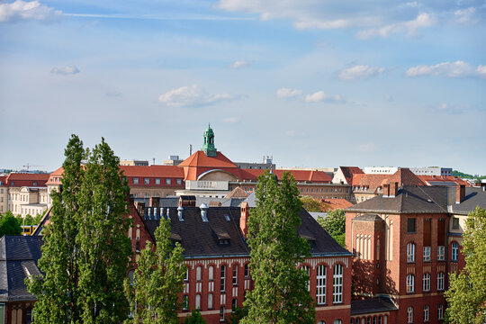 Historic red brick buildings and city rooftops under blue sky