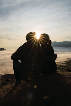 Couple embracing at sunrise overlooking Mount Bromo volcano Java