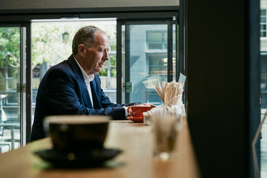 Businessman works on laptop in a coffee shop