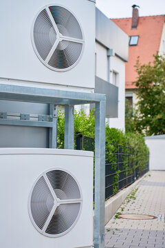 Outdoor heat pump units installed beside modern house