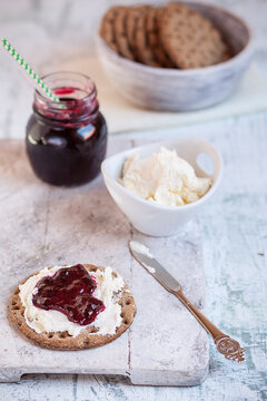 Round crispbread, cream cheese and currant jelly, knife