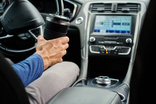 Driver with coffee cup inside car