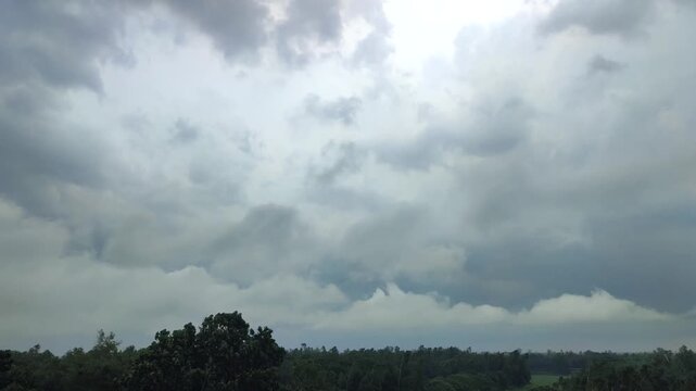 Dramatic Overcast Sky And Storm Clouds Rolling Over A Lush Green Forest Landscape