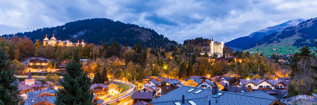 Switzerland, Canton of Bern, Gstaad, townscape with Gstaad Palace Hotel at dusk