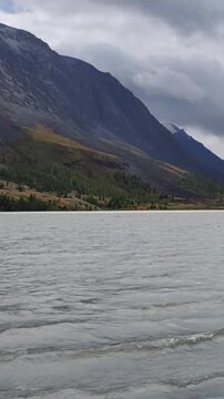 Slow-motion vertical video of Altai Lake Akkul. View towards the Sofiysky Glacier on the South Chuya Ridge.