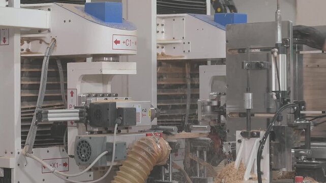 CNC woodworking machine milling a precision edge profile on a wooden board. Automated routing process creates an interlocking joint for furniture manufacturing and wood assembly.