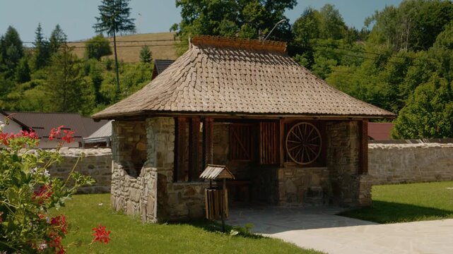 Visitors enjoy the summer terrace at Humor Monastery. The space features old paintings and a cozy atmosphere for relaxation and sightseeing in Bukovina.