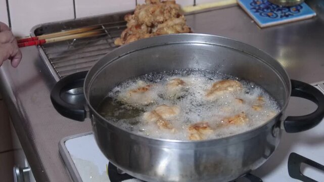 鶏のから揚げを揚げる女性