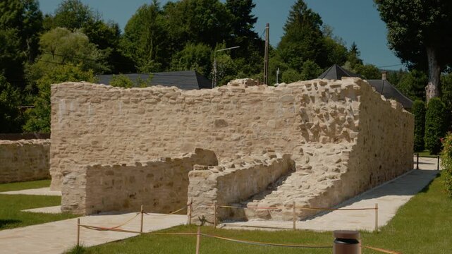 Visitors walk around the old walls of Humor monastery in Bukovina. The site shows ancient paintings and offers a glimpse into its rich history.