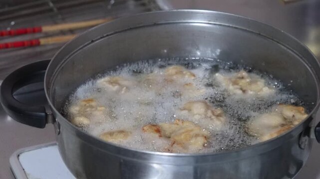 鶏のから揚げを揚げる女性