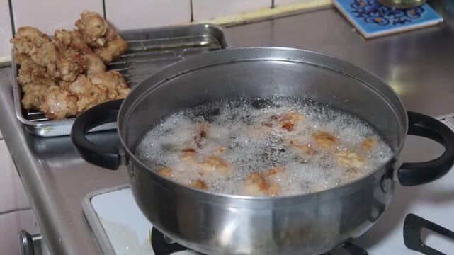 鶏のから揚げを揚げる女性
