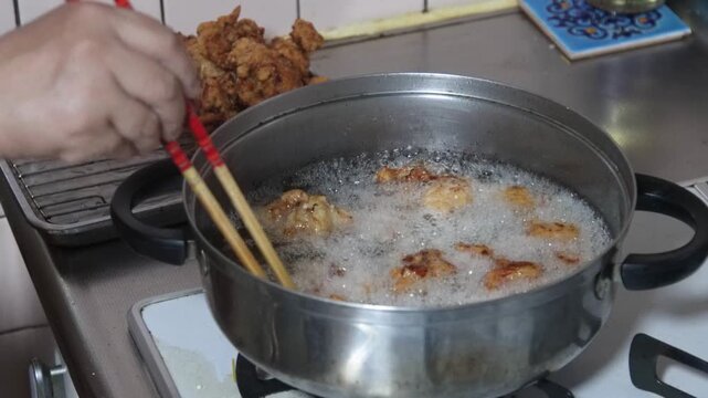 鶏のから揚げを揚げる女性