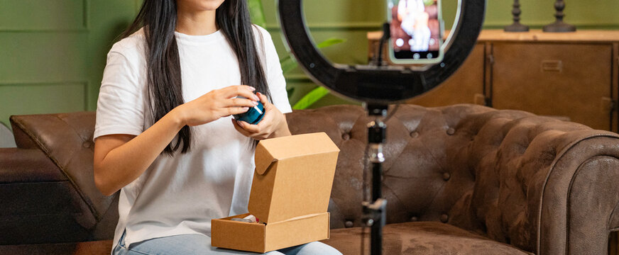 Woman unboxing product on video for her online social media channel