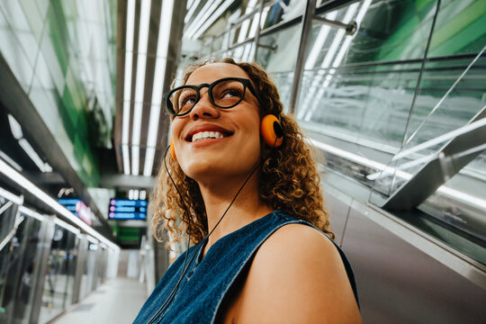 Woman listens to music during her commute in a city station