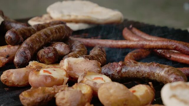 People gather to enjoy grilled potato and sausage pies at a street food festival in Bukovina. The aroma fills the air as food is prepared on the grill.