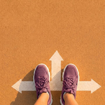 Person in purple sneakers standing before directional arrows on court