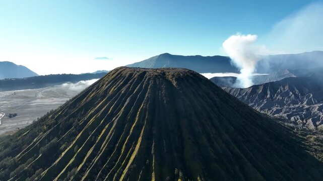 Mount Batok In The Foreground And The Active Mount Bromo Volcano In The Background Within The Bromo Tengger Semeru National Park In East Java, Indonesia. - aerial shot